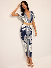 Dress with deep V-neck and tropical print, front view with hand on head