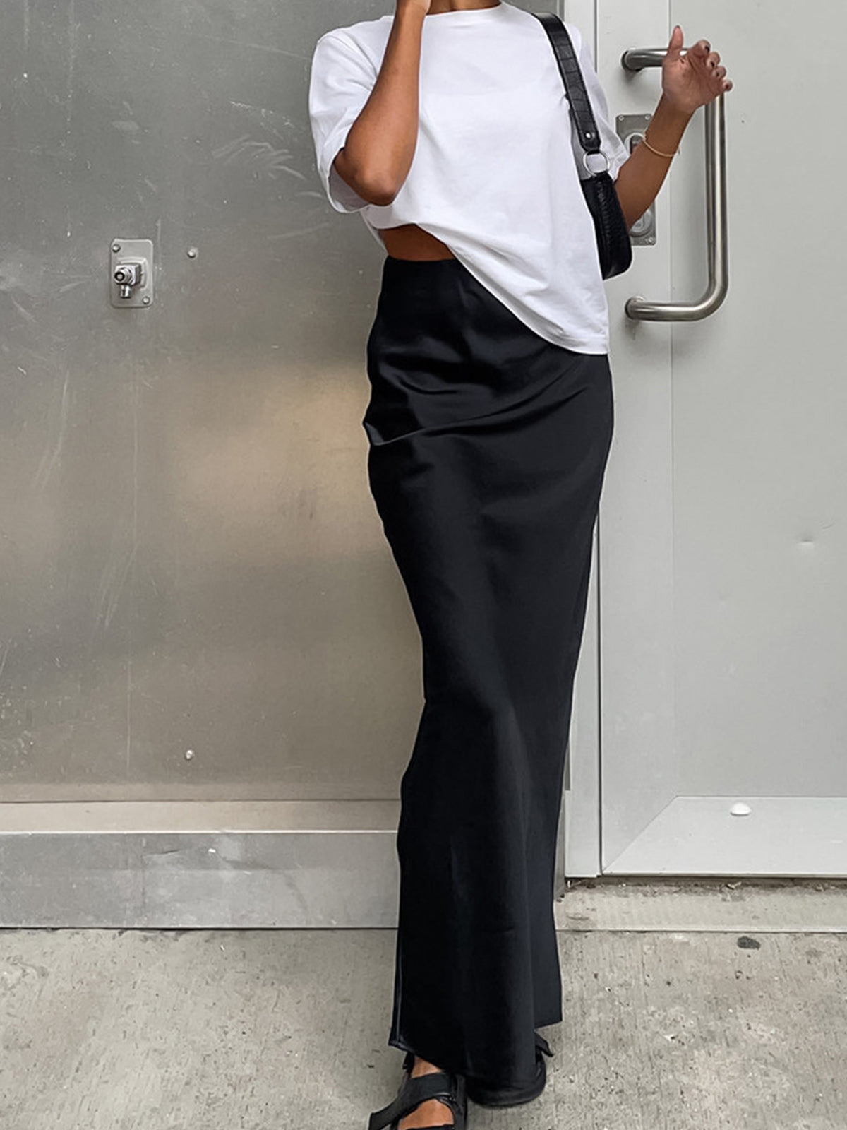 Black satin maxi skirt with flared hem front view