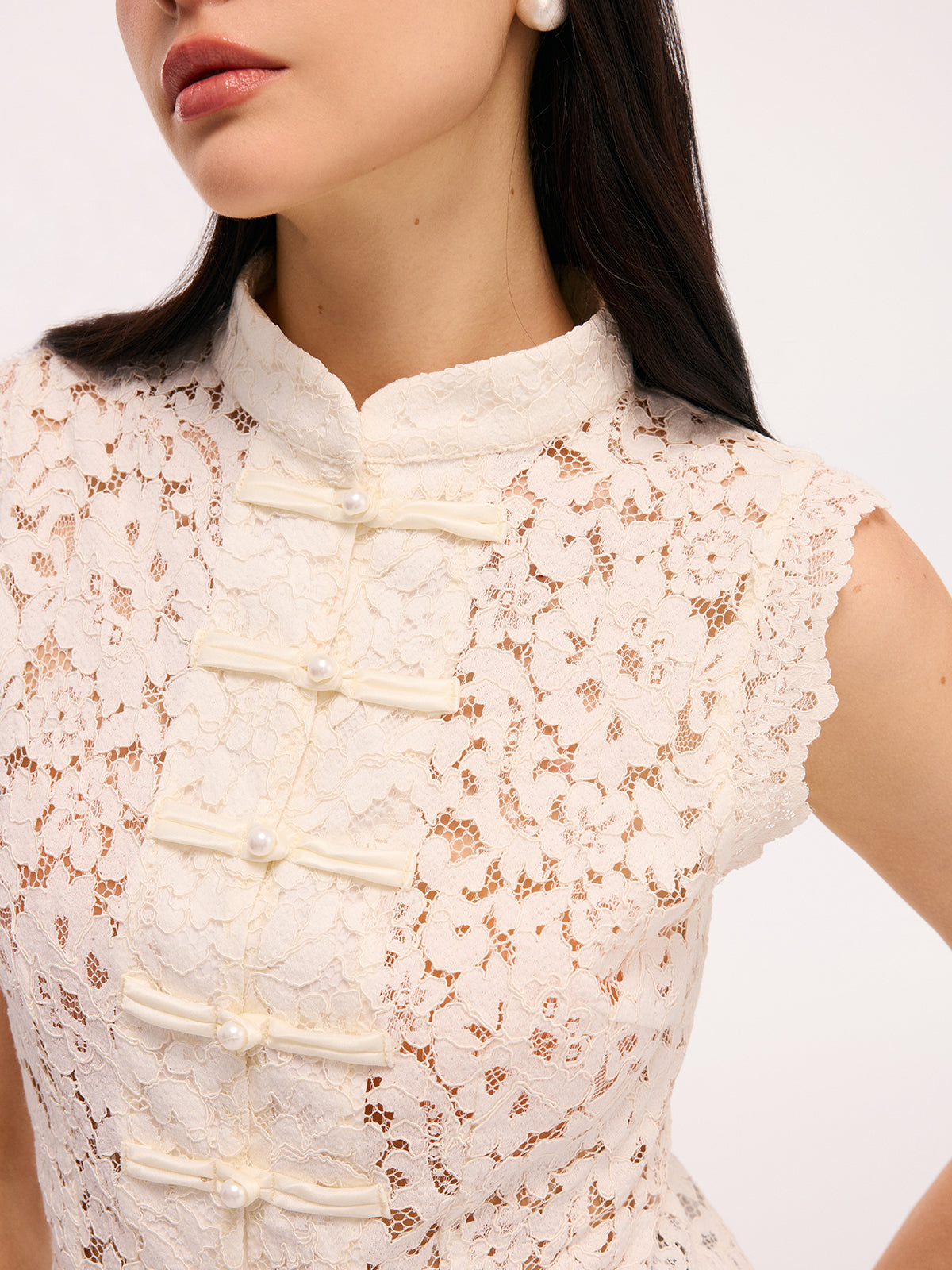 Cream lace blouse with pearl buttons close-up detail