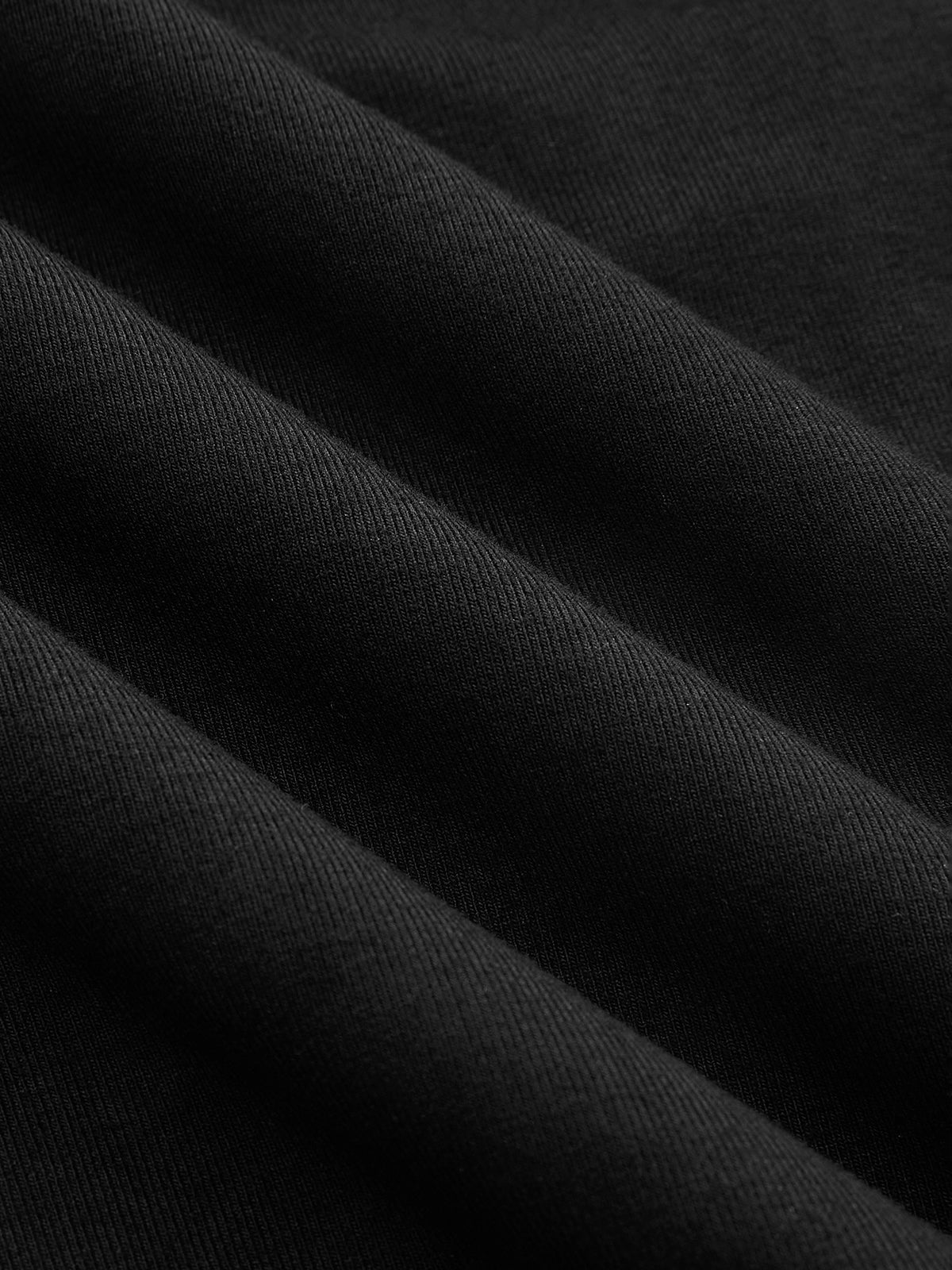 Black asymmetrical neck top with ruched detail fabric texture close-up