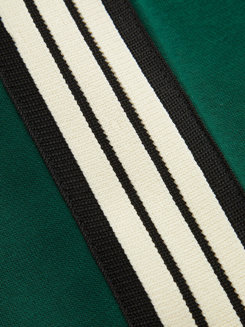 Green joggers white and black stripes close-up detail