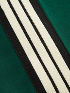 Green joggers white and black stripes close-up detail
