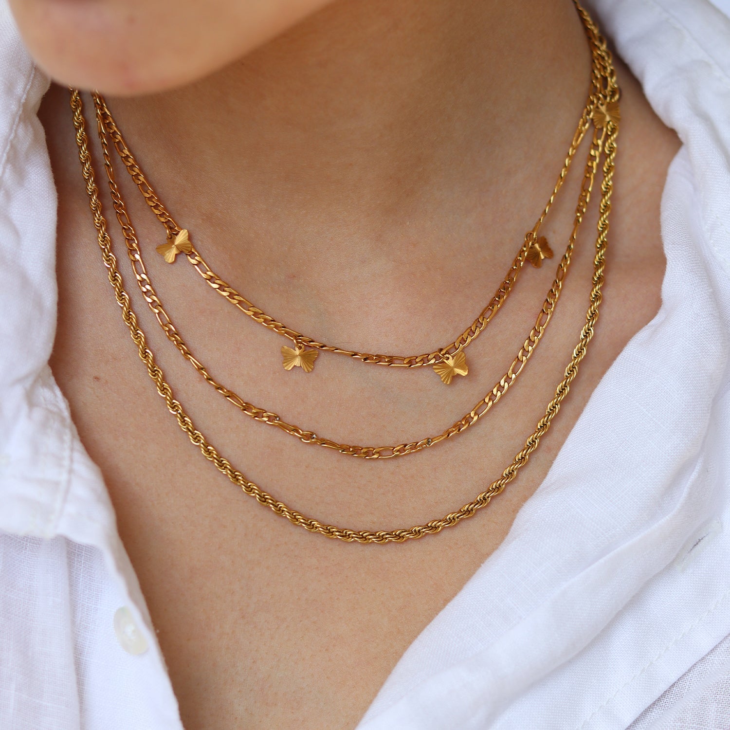Gold layered necklaces with charms worn on neck
