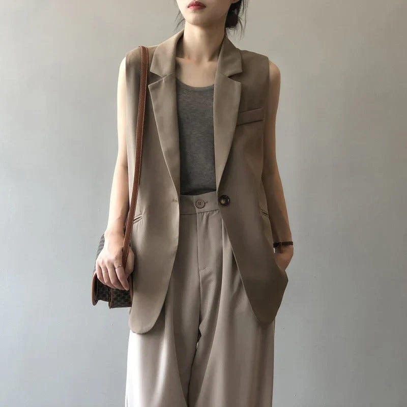 Beige sleeveless blazer vest front view with hands in pockets