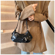 Black leather shoulder bag with buckle details worn on shoulder