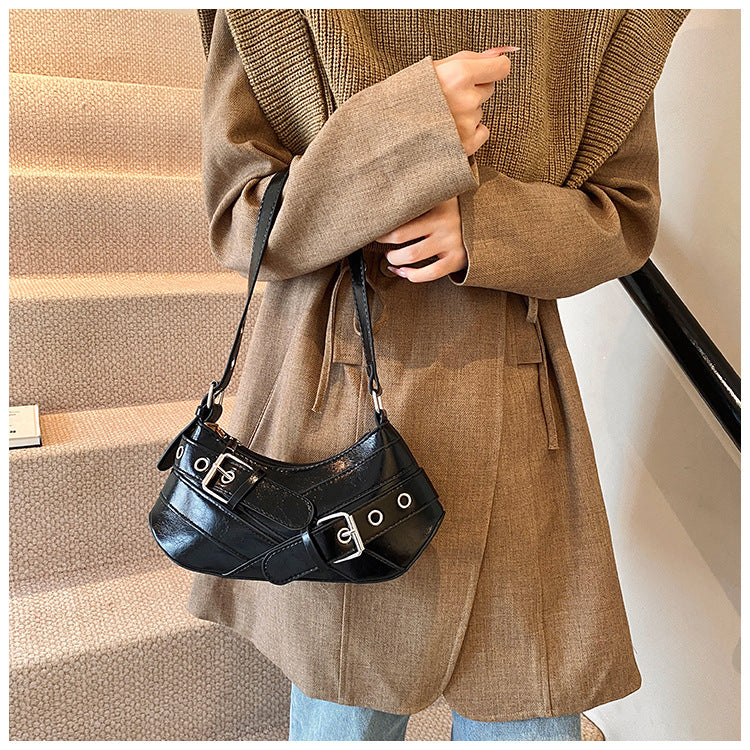 Black leather shoulder bag with buckle details worn on shoulder