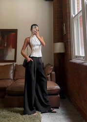 White pleated halter top worn with black pants full body view