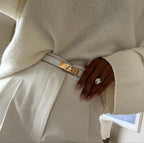 White leather belt with gold buckle worn with white dress