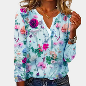 Blouse with vibrant floral print, light blue background, front view