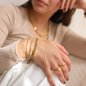 Gold-colored snake chain bracelet with extender, worn with other jewelry