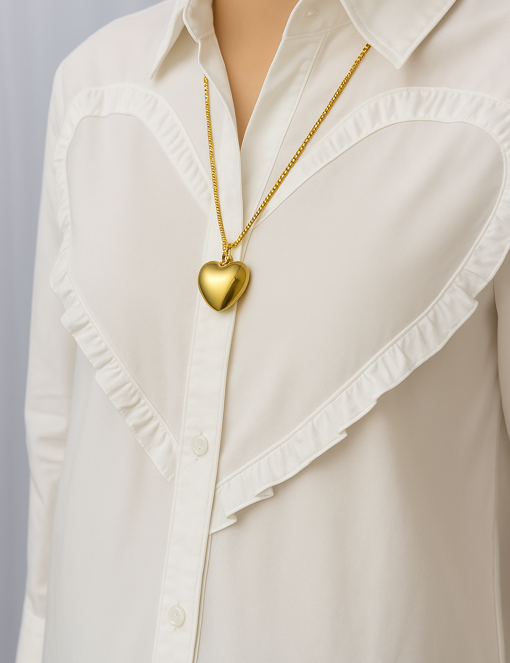 Gold heart pendant necklace worn on white blouse front view