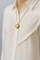 Gold heart pendant necklace worn on white blouse front view