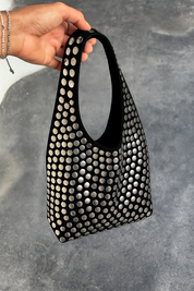 Black hobo bag with silver studs held in hand
