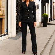 Kostuum met zwarte blazer en broek, goudkleurige knopen, zijprofiel