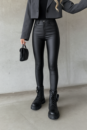 Zwart leerlook jeans strak model zijprofiel