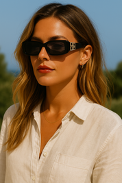Sunglasses with gold logo detail worn by model, front view