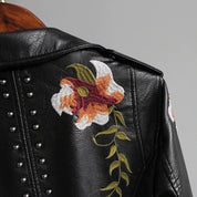 Black leather jacket with floral embroidery and studs, close-up of floral detail