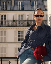 Blouse with ruched detailing and puff sleeves, side view with white shorts