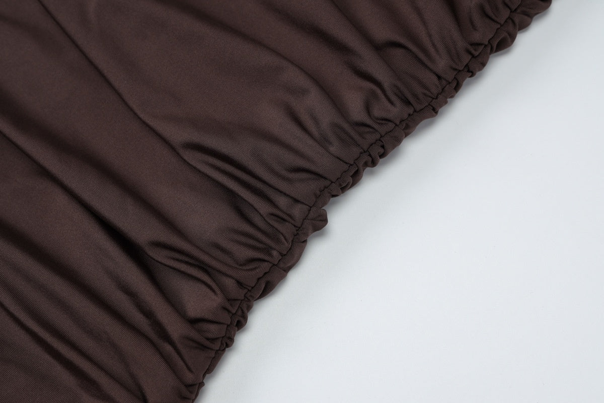 Kledingstuk met ruchedetail in donkere kleur, detailopname