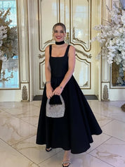 Black fit-and-flare dress front view on model indoors