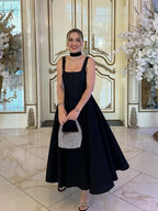 Black fit-and-flare dress front view on model indoors