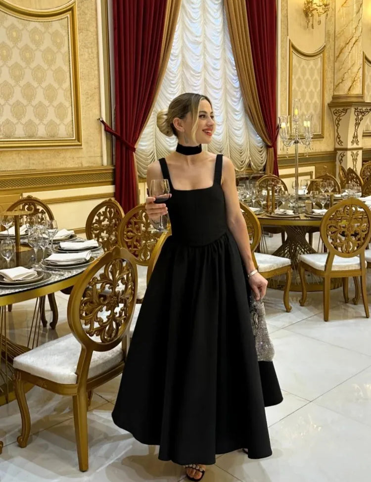 Black fit-and-flare dress side view on model in formal setting