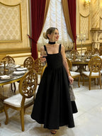 Black fit-and-flare dress side view on model in formal setting