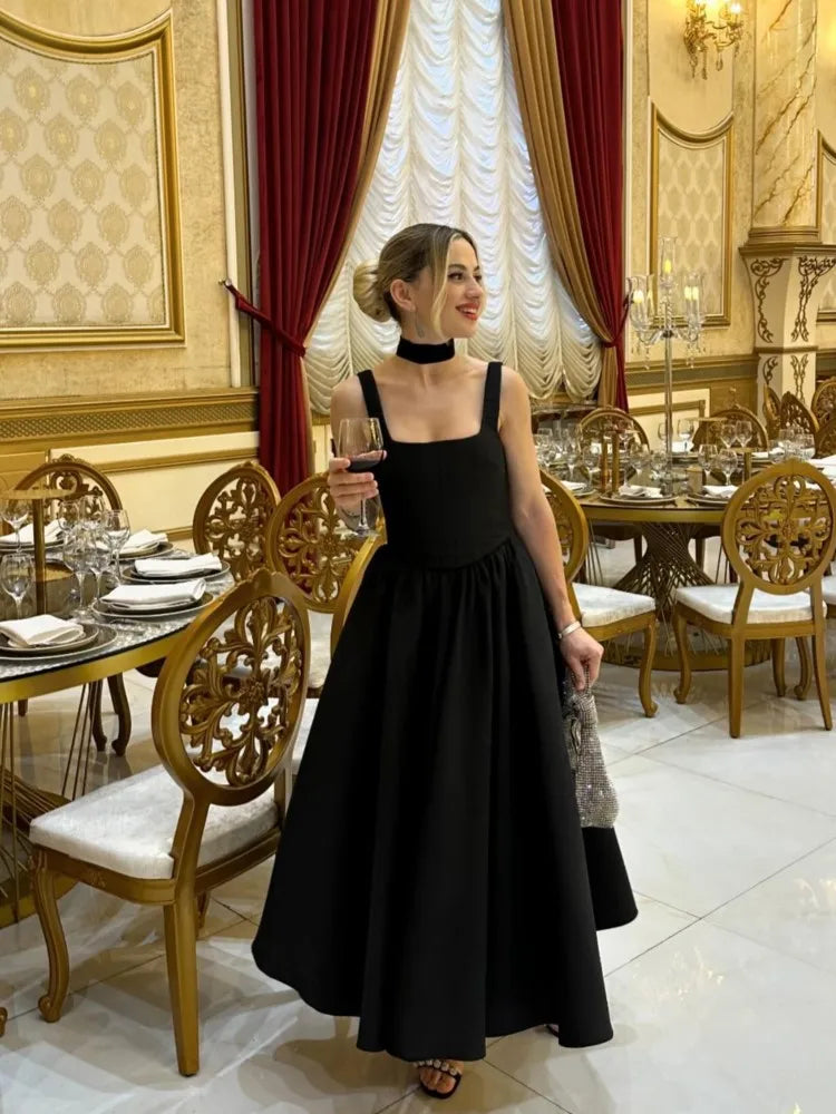 Black fit-and-flare dress side view on model in formal setting