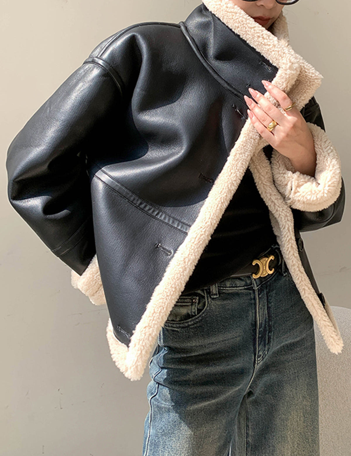 Women's black leather jacket with beige sherpa lining, front view