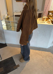 Cropped silhouette jacket brown side view with hands in pockets