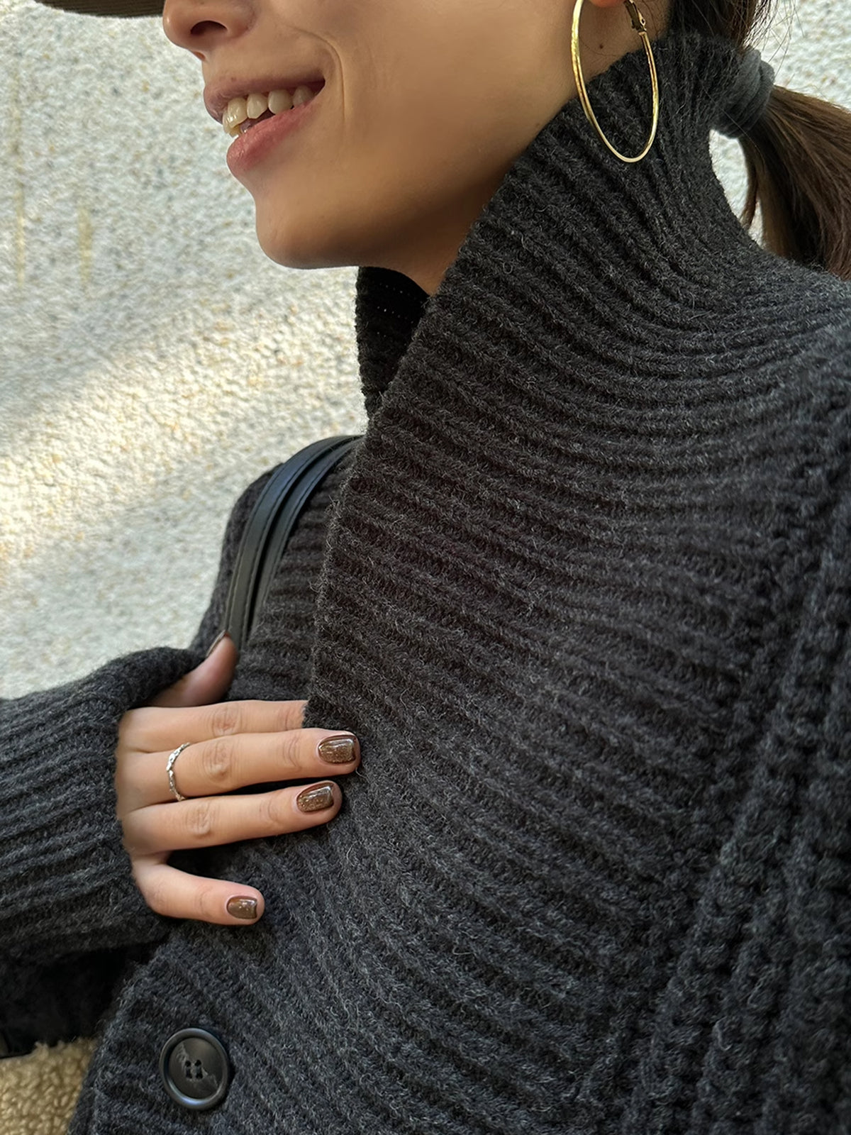 Close-up of black chunky knit cardigan high collar detail