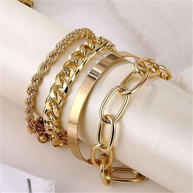 Gold metal bracelet set with chain, flat, and link styles shown on wrist from side angle