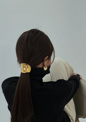 Gold hair cuff with organic texture, worn on ponytail, angled back view