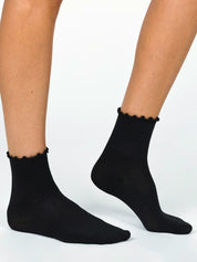 Black ruffled ankle socks worn on legs front view