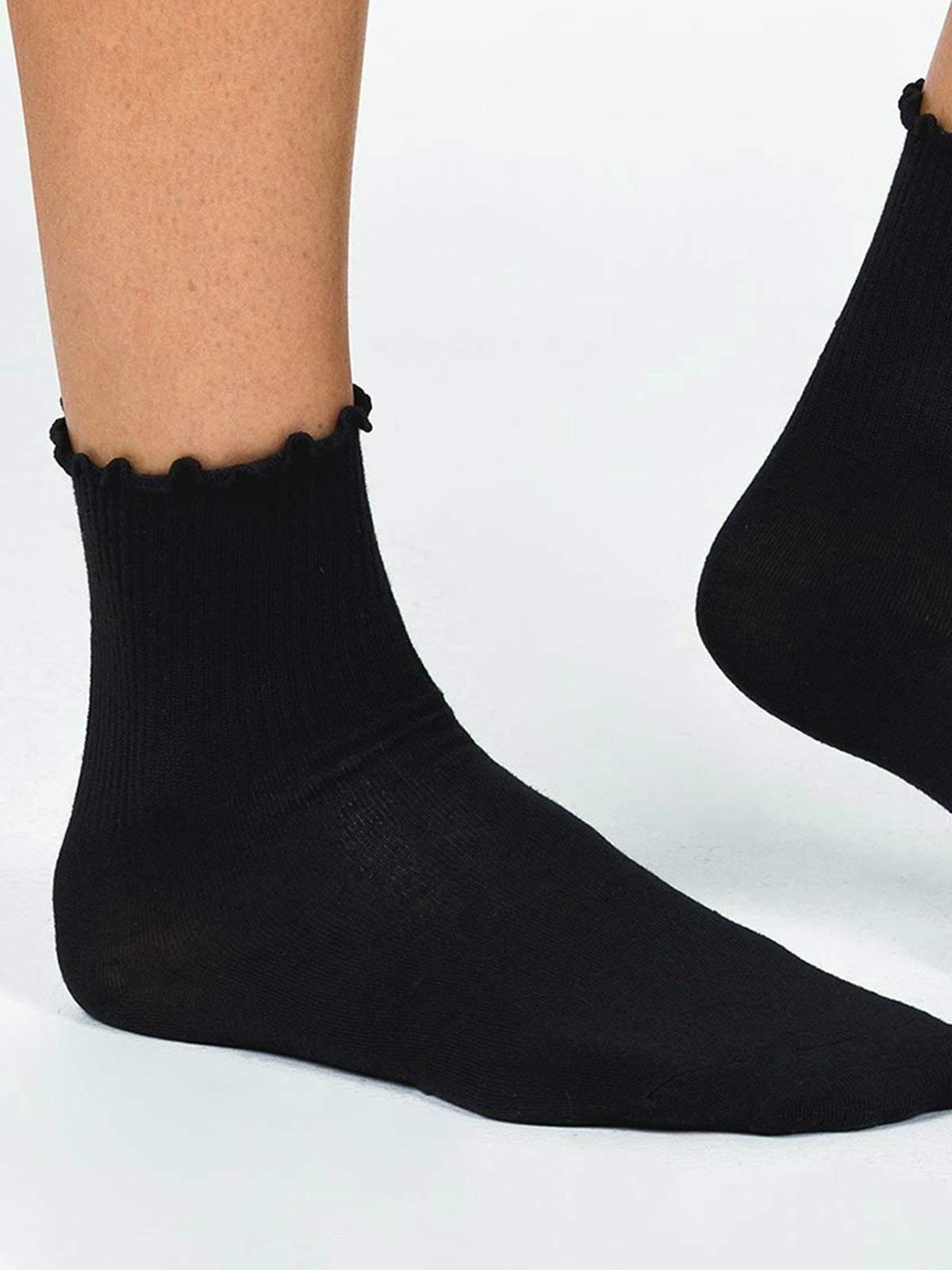 Black ruffled ankle socks worn on legs angled view