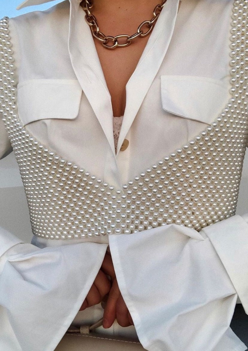Pearl grid bralette worn under white blazer with chain necklace close-up view