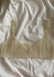 Synthetic pearl bralette laid flat on white fabric