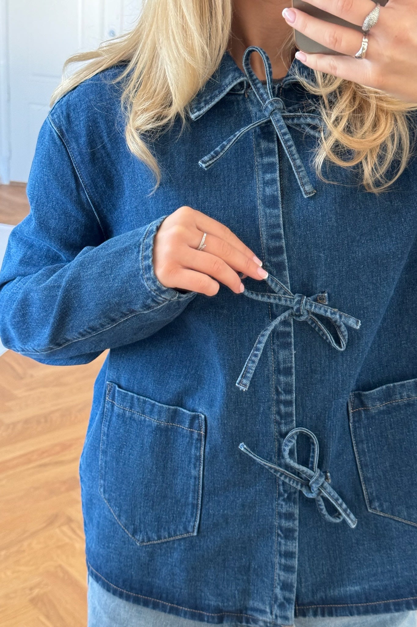 Close-up of denim jacket tie front detail and pockets