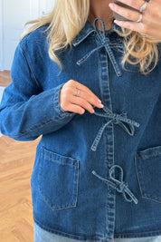 Close-up of denim jacket tie front detail and pockets