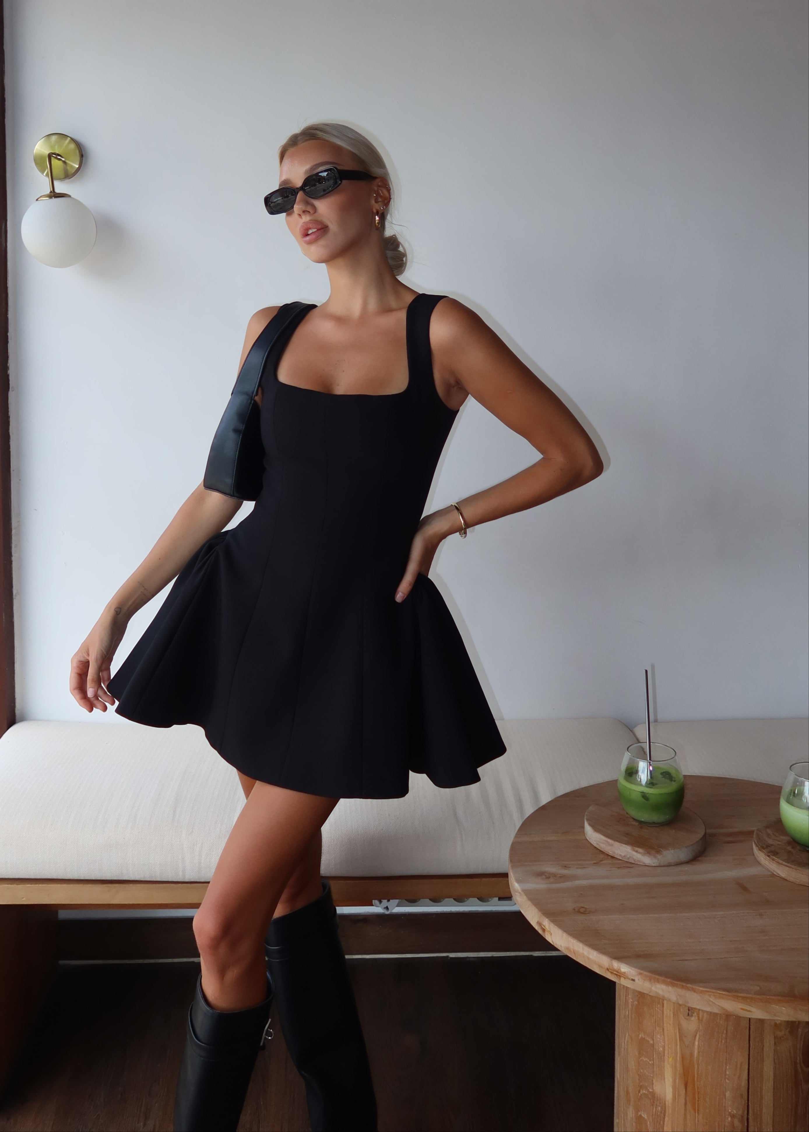 Black dress with structured flared skirt side view with accessories