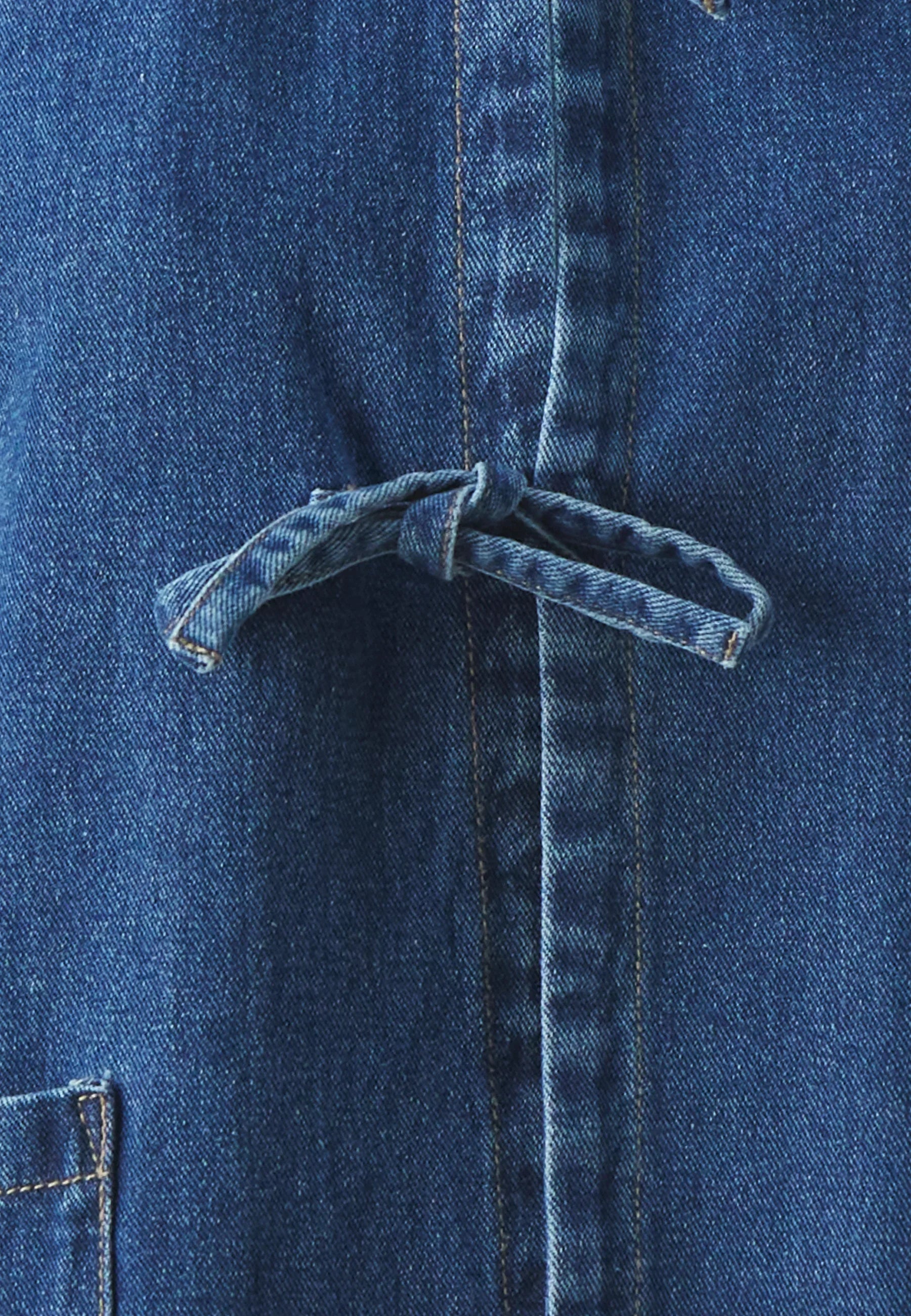 Close-up of denim jacket tie front detail fabric texture