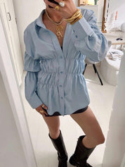 Blouse with ruched detailing and puff sleeves, side view with denim shorts