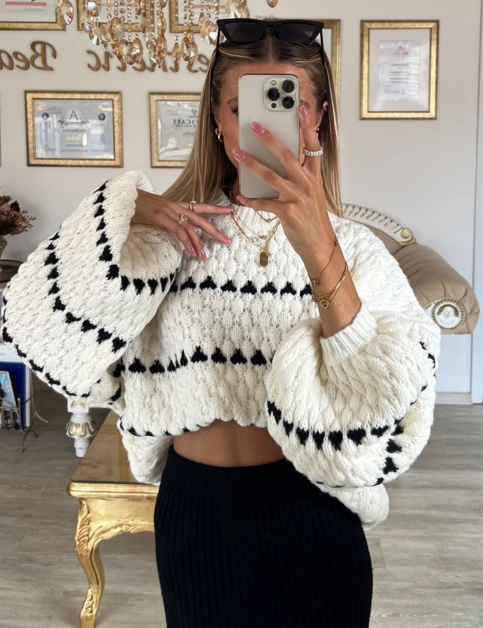Cream chunky knit sweater with black heart pattern, worn with black shorts, front view
