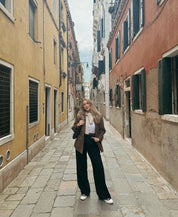 Brown suede-look blazer front view with model in narrow street