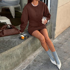 Brown blazer and skirt set with white boots and socks seated view