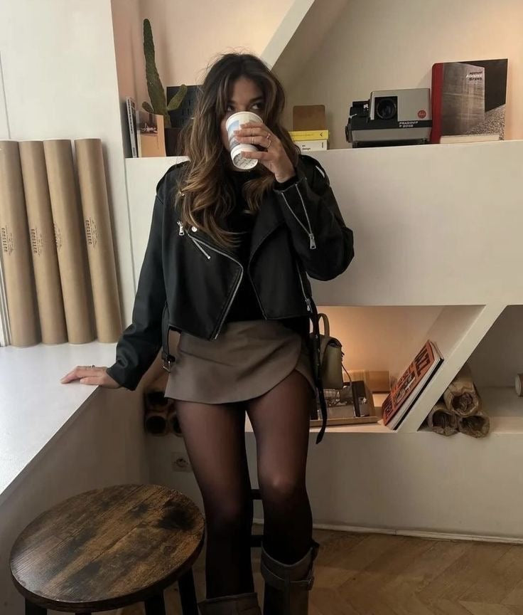Luxe skort beige met zwart jasje en laarzen, model zittend