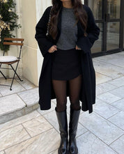 Korte rok zwart met jas en laarzen voorbeeld outfit