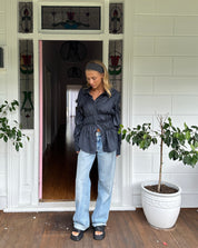 Blouse with ruched detailing and puff sleeves, front view with white shorts