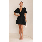 Black dress with deep V-neck and puffed sleeves side view