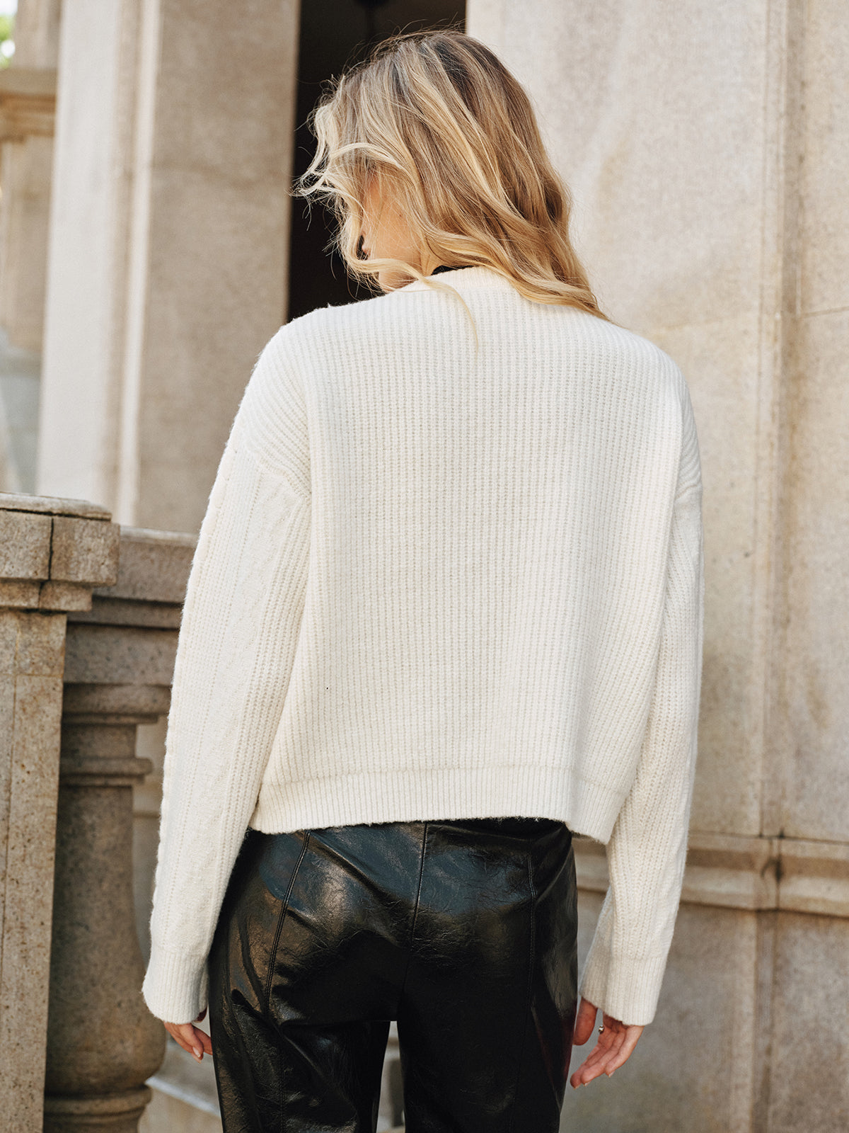 Cream knit vest with black buckle closures back view